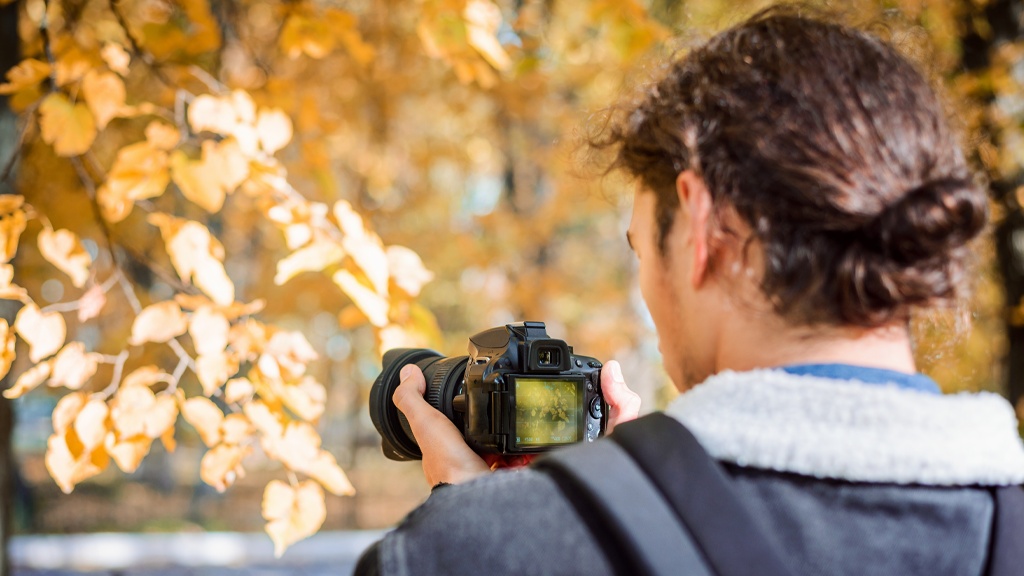 Photo of a man taking a picture of fall foliage for a photo contest fundraiser